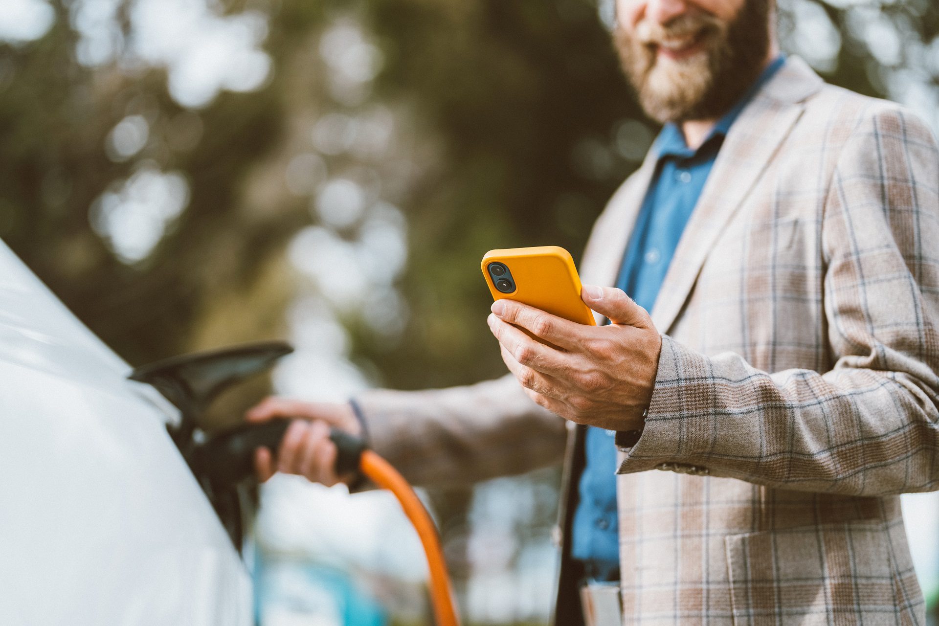 Businessman charging electric car